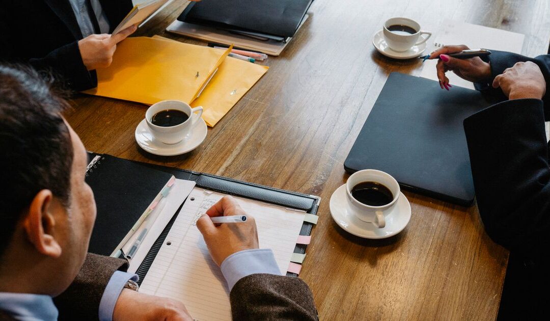 Diverse groep mensen overlegt rustig aan tafel tijdens een gesprek over de online echtscheiding